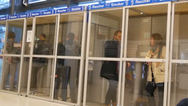 Wiedeń, Austria - 22 grudnia 2019: Lotnisko Wiedeń-Schwechat. Lotnisko palarnia pokój wypełniony palaczy. Dedykowana kabina dla niepalących. — Wideo stockowe