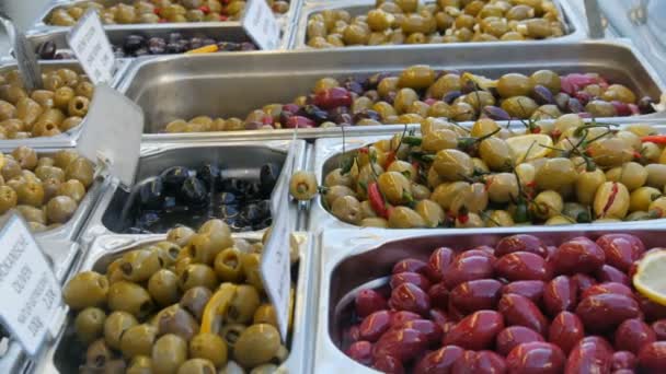 Comptoir de marché avec diverses olives farcies de vert, rouge, noir. Alimentation végétarienne — Video