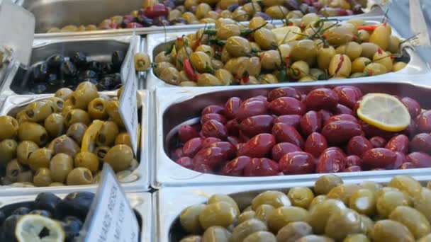 Marknads räknare med olika fyllda oliver av grönt, rött, svart. Vegetarisk mat — Stockvideo