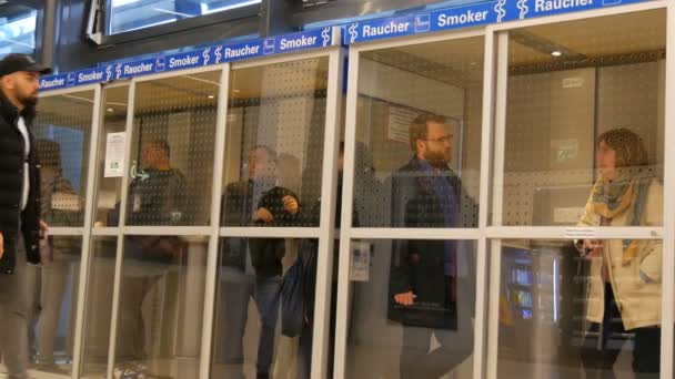 Vienna, Austria - December 22, 2019: Vienna-Schwechat Airport. Airport Smoking lounge room Filled With Smokers. Dedicated Small Smoking cabin. — Stock Video