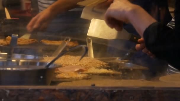 Chefs mãos em quiosque fast food preparar omeletes, panquecas, macarrão e outros pratos deliciosos. Vista lateral de mulheres e homens cozinha quatro mãos — Vídeo de Stock