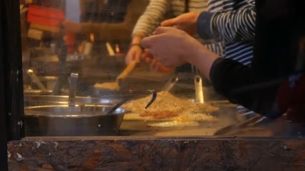 Szakácsok kéz gyorsétterem kioszk elkészíti omlett, palacsinta, tészta és más ízletes ételeket. Oldalnézet a nők és a férfiak főz négy kéz — Stock videók