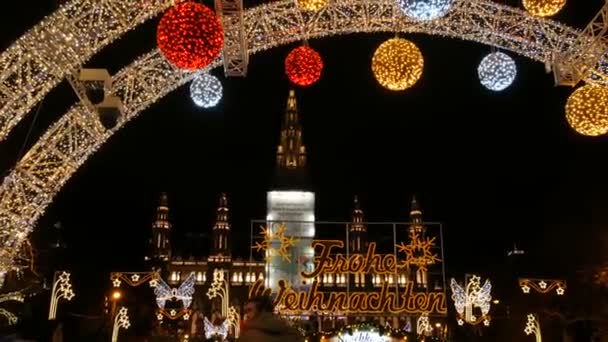 Viyana, Avusturya - 21 Aralık 2019: Belediye binasının önündeki Noel pazarı. Turistlerin ve yerlilerin yürüdüğü çelenklerle süslü bir meydan. Çeşitli yiyecek ve malzemelerle tezgahlar. — Stok video