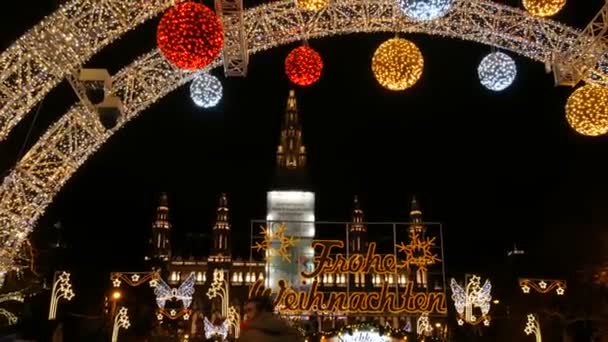 Vienna, Austria - December 21, 2019: Christmas market in front of the town hall. Festively decorated square with garlands near which tourists and locals walk. Stalls with various food and things — Stock Video