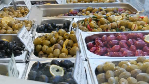 Marktenteller met diverse gevulde olijven van groen, rood, zwart. Vegetarisch voedsel — Stockvideo