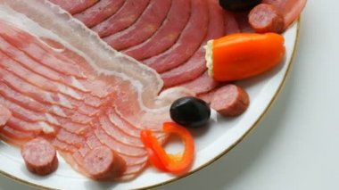 Siyah zeytinlerin yanında et ve sosis dilimleri, peynirli kırmızı biber ve avcı sosisi. Salam ve dilimlenmiş jambon. Restoranda kurutulmuş et. İştah açıcı. İyileştirilmiş et tabağı