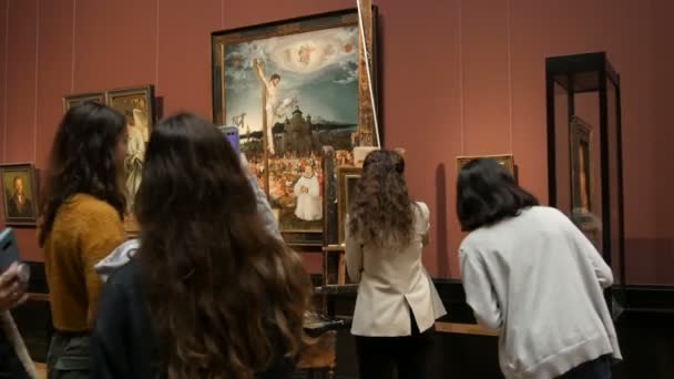 Wenen, Oostenrijk - 19 december 2019: Binnen in het Museum voor Kunstgeschiedenis. Kunstgalerie met wereldberoemde schilderijen. De kunstenaar schildert schilderijkopie van de beroemde kunstenaar aan de ezel in de kunstgalerie — Stockvideo