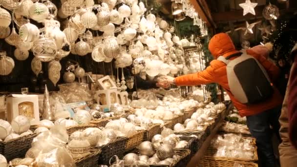 ウィーン、オーストリア- 12月21 、 2019:クリスマスマーケットのカウンターで白いガラスクリスマスのおもちゃや装飾ボール。ナイトショットウィーンクリスマスマーケット — ストック動画