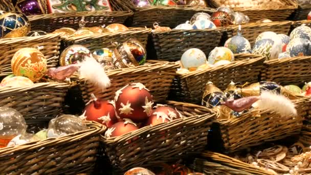 Bécs, Ausztria - 2019. december 21.: Üveg sokszínű festett karácsonyi játékok és dekorációs bálok a karácsonyi vásár pulton. Éjszakai felvétel a bécsi karácsonyi piacról — Stock videók