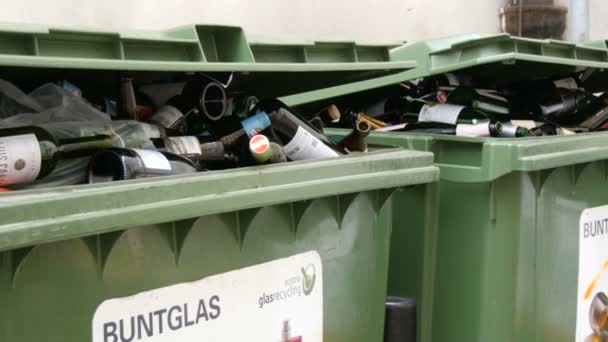 Bécs, Ausztria - 2019. december 19.: Műanyag szemeteskonténerek színes üvegpalackokhoz. Szemetet válogatok és újrahasznosítok. Környezetvédelem, hulladékválogatás. Felirat német nyelven — Stock videók