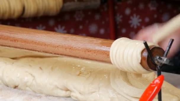 Wenen, Oostenrijk - 19 december 2019: Vrouwelijke handen wikkelen de deegstokjes op een houten stokje. Nationale Tsjechische trdelnik zoete delicatesse Traditionele Tsjechische en Hongaarse bakken zoete bakkerij — Stockvideo