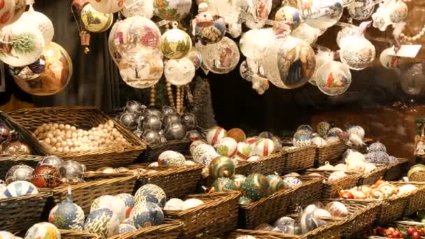 Viena, Austria - 21 de diciembre de 2019: Juguetes de Navidad pintados multicolores de vidrio y bolas de decoración en el mostrador del mercado de Navidad. Night shot Mercado navideño de Viena — Vídeo de stock
