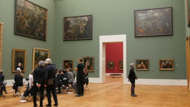 Mnichov, Německo - 17. prosince 2019: Skupina návštěvníků milovníků umění diskutuje o obrazech. Starý Pinakothek. Expozice krásných velkých světově proslulých obrazů umělců — Stock video