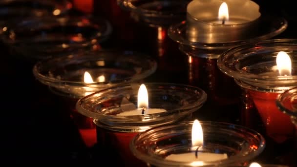 Bougies rondes rouges funéraires brûlantes dans le temple — Video