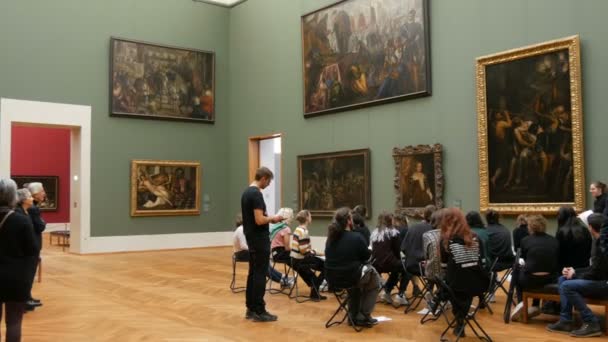 德国慕尼黑- 2019年12月17日：一群艺术爱好者的访客讨论绘画。 老皮纳科德克 艺术家们的美丽的世界名画展览 — 图库视频影像