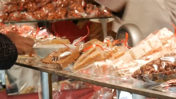 Julstånd med sötsaker. Säljaren säljer godis. Köparen betalar för köpet — Stockvideo