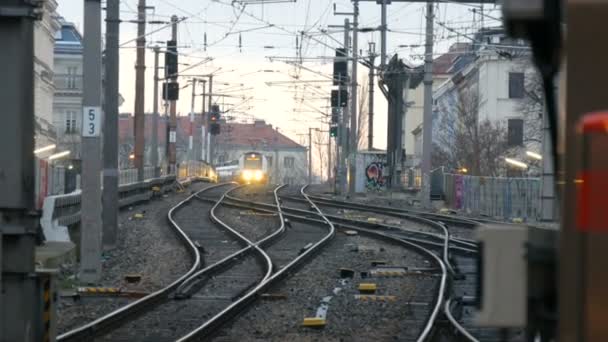 Tren istasyonunda gün doğumu ya da gün batımı. Tren raylara çıkıyor. İstasyonda bir sürü tren yolu var. — Stok video