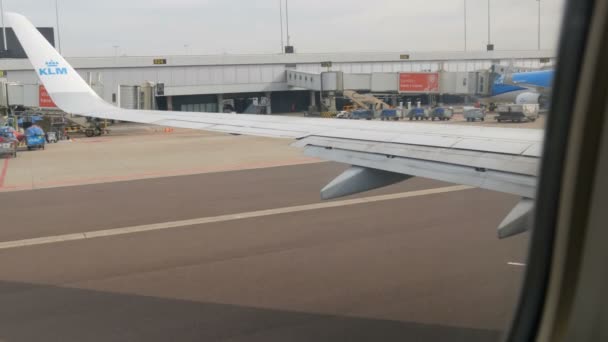 Amsterdam, Paesi Bassi - 26 aprile 2019: Aeroporto di Schiphol, uno dei più grandi al mondo. Un aereo è in fase di preparazione per il decollo, guidando oltre i terminal aeroportuali — Video Stock