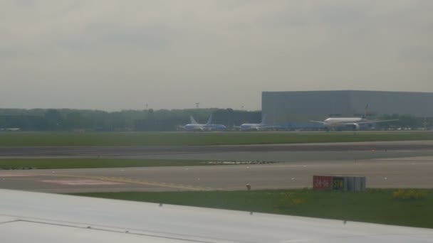 Amsterdam, Nederländerna - 26 april 2019: Schiphols flygplats, en av världens största. Ett flygplan förbereds för start, kör förbi flygplatsen — Stockvideo