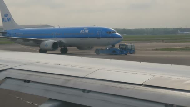 Amsterdam, 26 april 2019: Schiphol Airport, een van de grootste ter wereld. Er wordt een vliegtuig klaargemaakt om op te stijgen, langs een vliegtuig te rijden dat staat en opstijgt. — Stockvideo