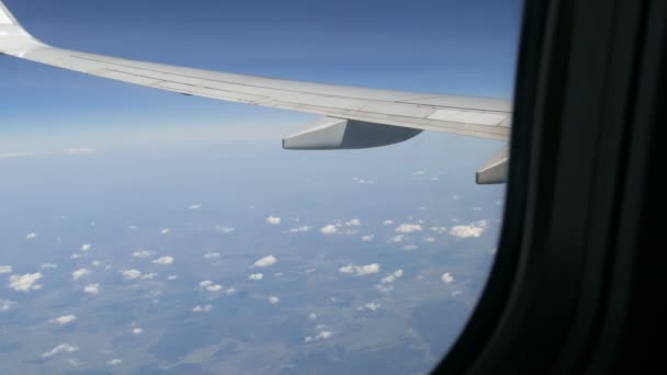 L'aereo sorvola le rare soffici nuvole. Campi d'Europa vista dall'oblò sull'ala dell'aeromobile — Video Stock
