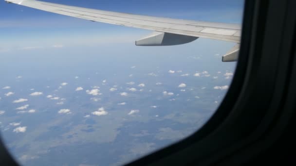 L'aereo sorvola le rare soffici nuvole. Campi d'Europa vista dall'oblò sull'ala dell'aeromobile — Video Stock