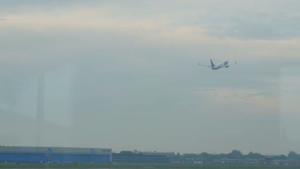 Schiphol国际机场跑道候机楼窗口的飞机起飞处 — 图库视频影像