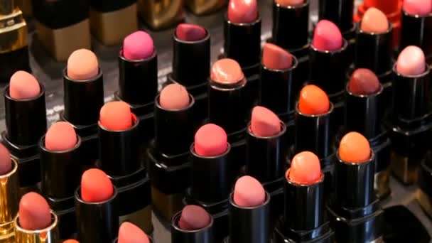 Tienda de cosméticos de moda de lujo. Soportes con variedad de lápices labiales de diferentes colores, cosméticos profesionales para mujeres — Vídeos de Stock