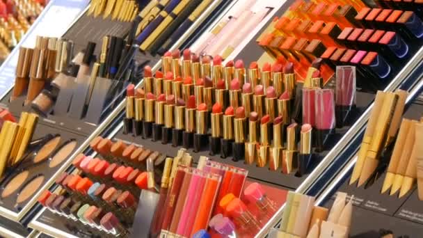 Ámsterdam, Países Bajos - 25 de abril de 2019: Tienda de cosméticos de moda de lujo. Soportes con variedad de cosméticos decorativos, lápiz labial, rímel, brillo, sombra de ojos — Vídeos de Stock