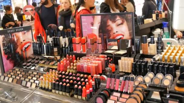 Ámsterdam, Países Bajos - 25 de abril de 2019: Tienda de cosméticos de moda de lujo. Soportes con variedad de cosméticos decorativos, lápiz labial, rímel, brillo, sombra de ojos — Vídeo de stock