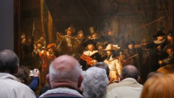 Амстердам, Нідерланди - 25 квітня 2019: Люди дивляться фільм Нічна сторожа Рембрандта, в Рейксмузеї. Натовп туристів, які цікавляться мистецтвом. — стокове відео