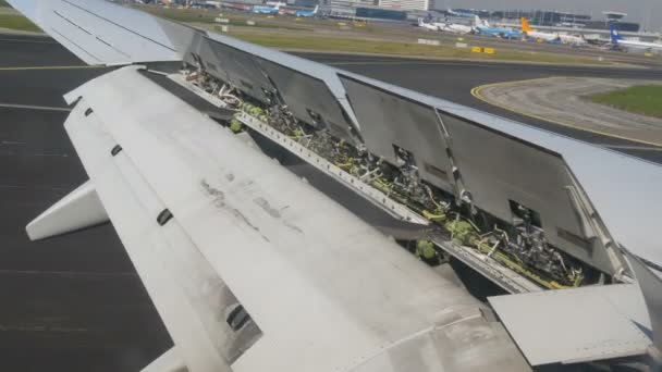 Амстердам, Нідерланди-21 квітня 2019: літак приземляється в одному з найбільших аеропортів світу, Схіпхол. Багато інших повітряних суден розташовані біля терміналів — стокове відео