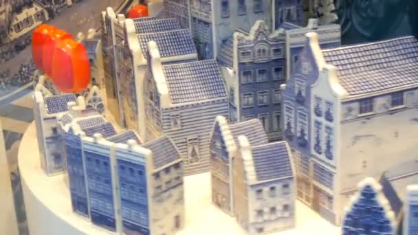 Casas rodantes de porcelana azul y tulipanes rojos al estilo holandés, en escaparate en Amsterdam, Países Bajos — Vídeos de Stock