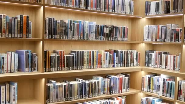 Amsterdam, Netherlands - April 24, 2019: Modern new shelving with bookshelves with various books in public library — Stock Video