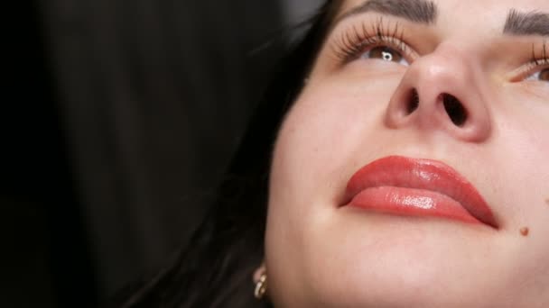 Gesicht eines jungen schönen Mädchens. Endergebnis der permanenten Lippenpflege. Mädchen hellrote Lippen in Nahaufnahme — Stockvideo