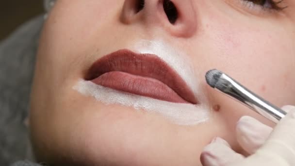 Microblading, micropigmentatie lippen werken stroom in een schoonheidssalon. Vrouw met een met potlood getrokken en getinte lip, die zich voorbereidt op semi-permanente make-up — Stockvideo