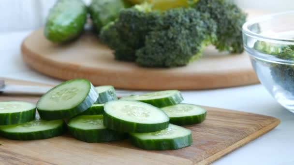 Pedaços de pepino picado em uma placa de cozinha de madeira. Alimentos veganos saudáveis . — Vídeo de Stock