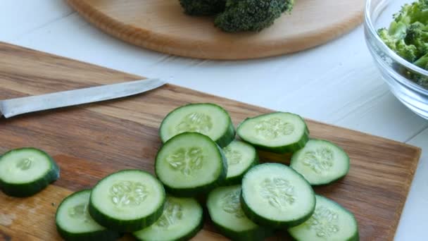 Trozos de pepino picado en una tabla de cocina de madera. Comida vegana saludable . — Vídeos de Stock