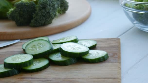 Pedaços de pepino picado em uma placa de cozinha de madeira. Alimentos veganos saudáveis . — Vídeo de Stock