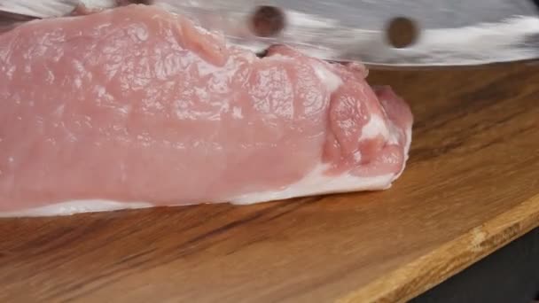 Nahaufnahme weiblicher Hände eines Kochs, der mit einem großen Küchenmesser frische Stücke Schweinespeck auf einem Holzbrett im rustikalen Stil schneidet — Stockvideo