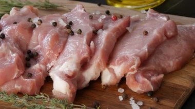 Köy usulü, siyah ve kırmızı biber ve kaba tuzla süslenmiş ev yapımı kesme tahtasının üzerinde taze, pembe domuz eti.