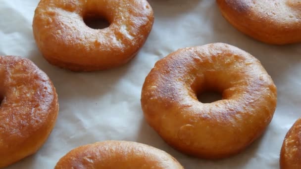 Donuts redondos grandes recém-fritos na mesa na cozinha da casa. Donuts sem esmalte e em pó — Vídeo de Stock
