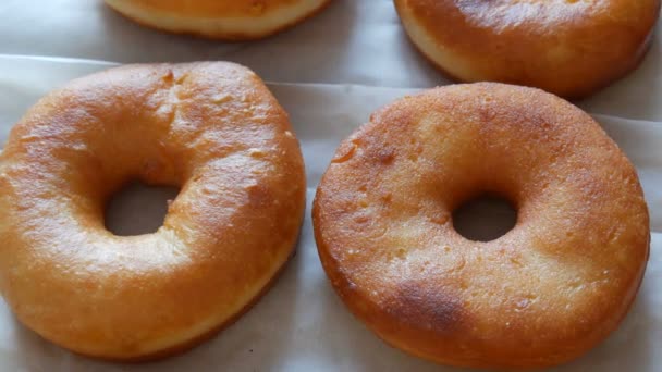 Recién frito grandes rosquillas redondas en la mesa en la cocina del hogar. Donuts sin esmalte y en polvo — Vídeos de Stock