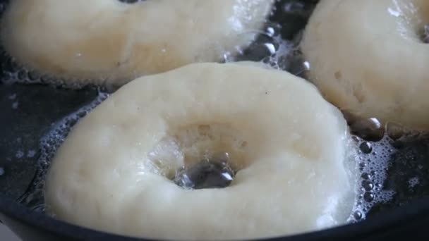 Köstliche Donuts in der Pfanne braten. Große Donuts werden in heißem Öl in einer Pfanne gebraten. Hausgemachtes Backen — Stockvideo