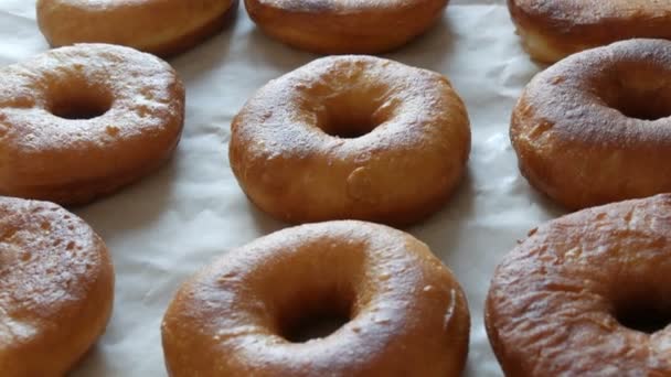 Donuts redondos grandes recém-fritos na mesa na cozinha da casa. Donuts sem esmalte e em pó — Vídeo de Stock