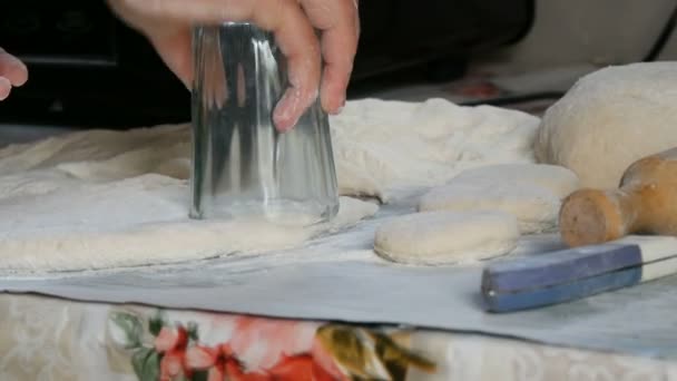 손을 사용하는 여자들은 시골 방식으로 미래에 집에서 집에서 만든 파이를 만드는데 사용 할 잔을 가지고 반죽으로 형태를 만든다. — 비디오