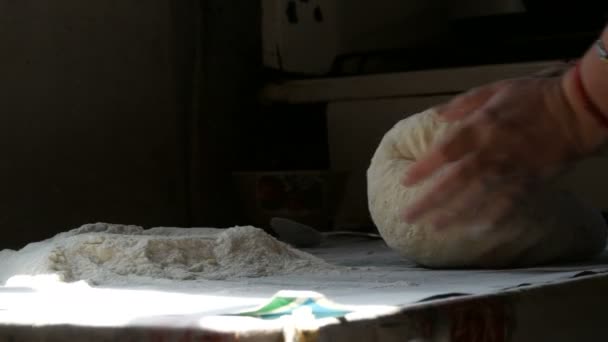 Female hands knead the dough on a black background in a rustic style. Flour flies in the air — Stock Video
