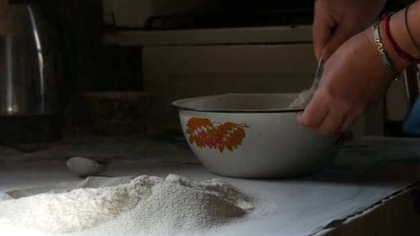 Female hands knead the dough in a bowl on a black background in a rustic style. — Stock Video