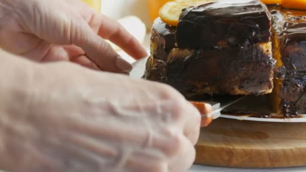 Les mains féminines prennent un gros morceau de gâteau éponge avec des tranches d'orange et de glaçage au chocolat. Aliments sucrés diabétiques — Video