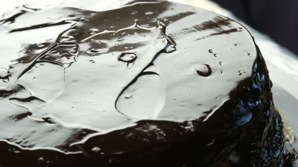 ビューを閉じます。Woman spreading a hocolate glaze on a sponge cake.女性の手はケーキの上にナイフでクリームを注ぎ、台所でオレンジビスケットやスポンジケーキ生地に広がり始めます。 — ストック動画